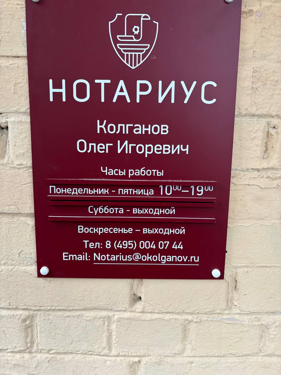 Информационная табличка нотариуса Колганова О. И. с часами работы у входа в контору