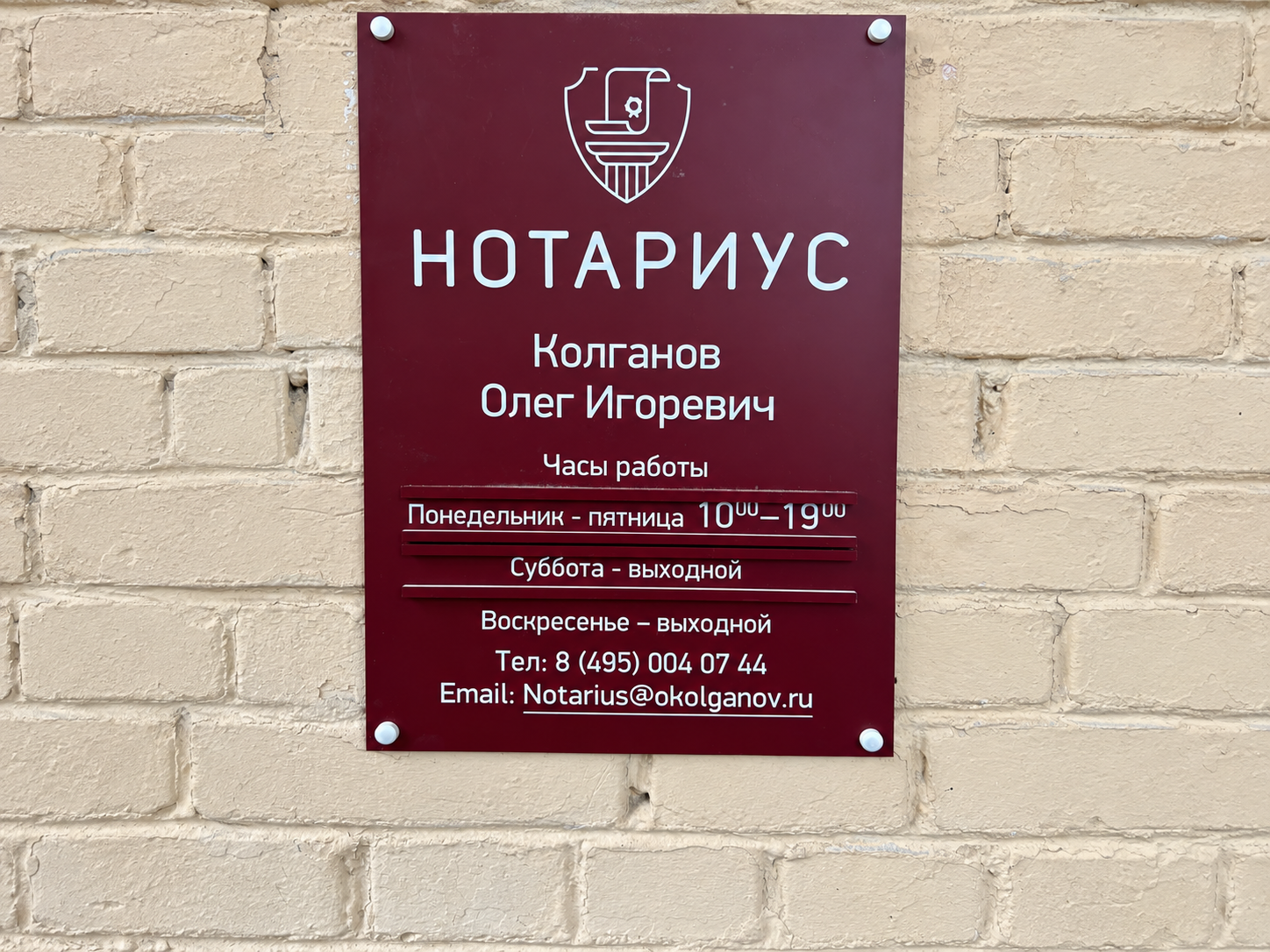 Информационная табличка нотариуса Колганова О. И. с часами работы у входа в контору